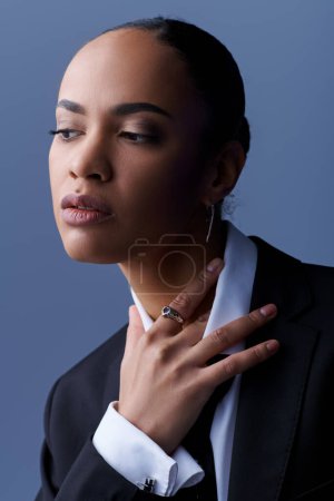 Jeune femme afro-américaine respire la confiance dans un costume sur mesure et un collier de déclaration.