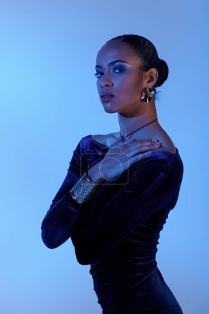 A young African American woman elegantly poses in a black dress.