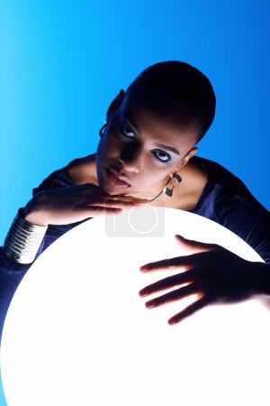 A young African American woman delicately holds a large white object in her hands.