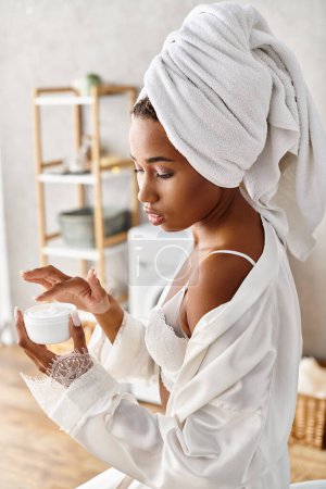 African American woman with afro braids holding a jar of cream in modern bathroom, promoting beauty and hygiene.
