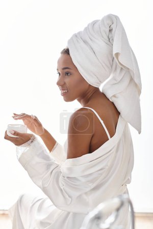 Femme afro-américaine enveloppée dans une serviette après un bain, incarnant la beauté et l'hygiène.