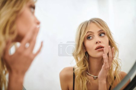 A woman looking at her reflection in a mirror.