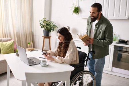 positive behinderte Frau im Rollstuhl, die zu Hause neben ihrem lesenden Mann arbeitet