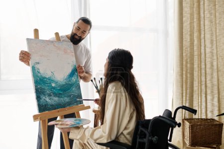 beautiful woman with mobility disability painting on easel next to her cheerful bearded husband