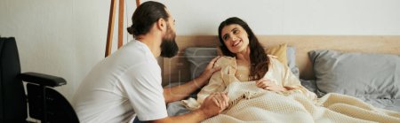 joyous woman with mobility disability lying in bed next to her bearded loving husband, banner