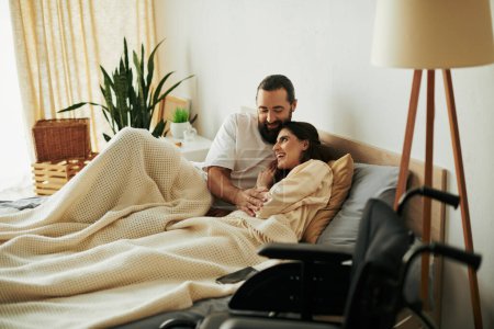 atractiva mujer alegre con discapacidad de movilidad tumbada en la cama junto a su marido barbudo amoroso