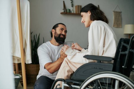 Foto de Hombre alegre de buen aspecto pasar tiempo con su hermosa esposa discapacitada, mientras que en el dormitorio en casa - Imagen libre de derechos