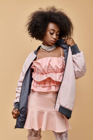 Photo for African american girl in 20s, posing in pastel outfit with jacket on beige background, peach fuzz - Royalty Free Image