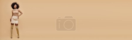 Photo for Stylish african american woman in pastel mini skirt and thigh-high boots on a beige backdrop, banner - Royalty Free Image
