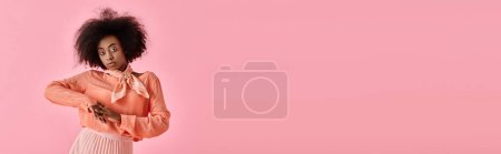 Photo for Pretty african american woman in peach blouse, midi skirt and neck scarf posing on pink, banner - Royalty Free Image