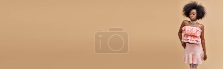 Photo for Banner, curly african american woman in peach ruffled top and mini skirt posing on beige background - Royalty Free Image