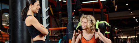 glücklich schöne Frau und ihre athletische Trainerin beim Training mit Powerbag im Fitnessstudio, Banner