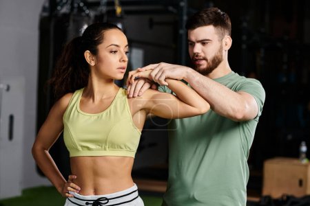 A male trainer teaches self-defense techniques to a woman in a gym, focusing on empowerment and unity.