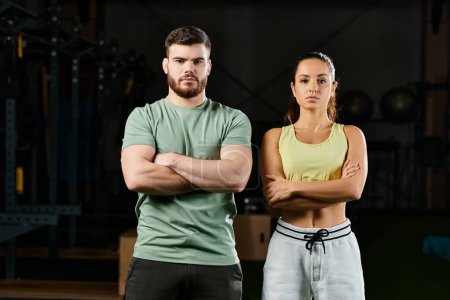 A male trainer teaching self-defense techniques to a woman in a gym, both standing confidently next to each other.