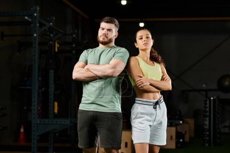 Un entrenador masculino demuestra técnicas de autodefensa a una mujer en un gimnasio, centrándose en la fuerza y la creación de confianza.