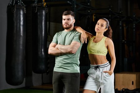 Un entraîneur masculin enseigne à une femme les techniques d'autodéfense dans un gymnase.