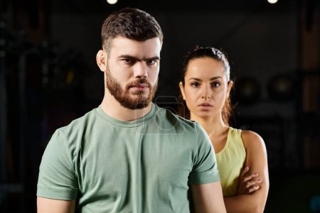 Entrenador masculino demuestra técnicas de autodefensa a una mujer en un gimnasio.