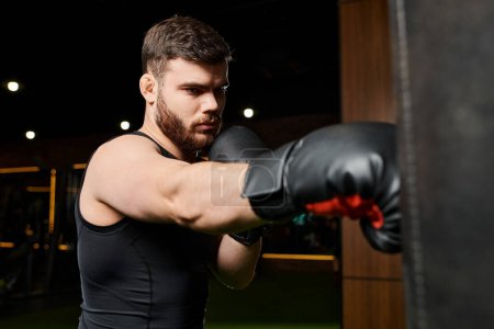 Un hombre guapo con barba usando guantes de boxeo, lanzando puñetazos a un saco de boxeo en un gimnasio.