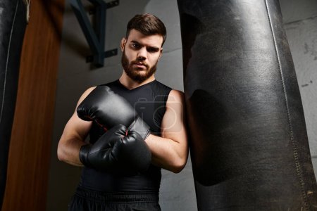 Schöner bärtiger Mann im Fitnessstudio, der zielstrebig und fokussiert Schläge auf Boxsack wirft.