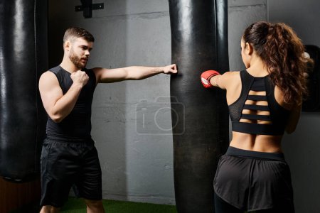 Ein männlicher Trainer führt eine brünette Sportlerin in aktiver Kleidung, wie sie in einem Boxring während einer rigorosen Trainingseinheit spatzt.