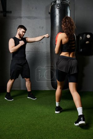 A male trainer supports a brunette sportswoman as she boxes in a modern gym environment.