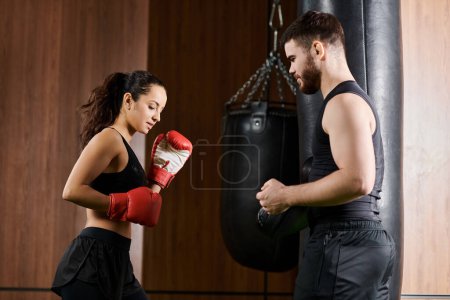 Ein männlicher Trainer in der Nähe einer brünetten Sportlerin im aktiven Boxsport in einem Fitnessstudio.