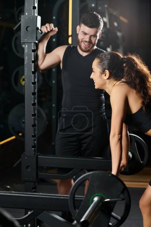 Ein männlicher Personal Trainer führt eine glückliche brünette Sportlerin durch eine Trainingseinheit in einem Fitnessstudio.