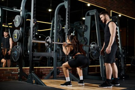 A personal trainer and a brunette sportswoman synchronously perform squats in a well-equipped gym.
