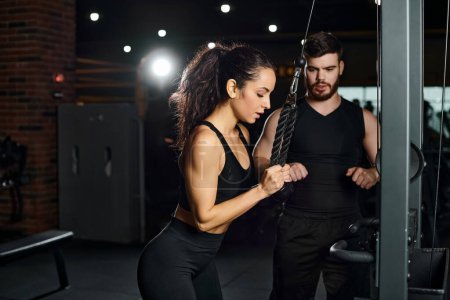 Ein Personal Trainer motiviert eine brünette Sportlerin während einer intensiven Trainingseinheit im Fitnessstudio.