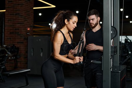 A personal trainer is guiding a brunette sportswoman through a workout routine in a vibrant gym setting.