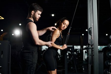 personal trainer assists a brunette sportswoman in a gym as they engage in a workout session together.