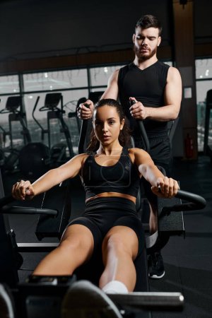 A male trainer guides a focused brunette sportswoman in a gym workout session, pushing each other to reach their fitness goals.