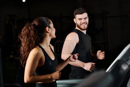Ein Personal Trainer steht neben einer brünetten Sportlerin in einem Fitnessstudio, bereit für eine Trainingseinheit.