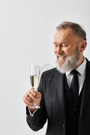 Ein Bräutigam mittleren Alters im eleganten Anzug hebt zur Feier seines Hochzeitstages ein Glas Champagner.