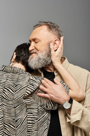 A middle aged couple in stylish attire embracing each other with joy in a studio setting.