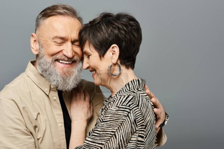 Photo for A middle-aged man and woman, dressed stylishly, wrapped in a tender embrace in a studio setting. - Royalty Free Image