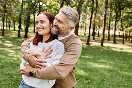 Ein Mann umarmt eine Frau in einem Park liebevoll.
