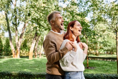 Un hombre y una mujer riendo juntos en un parque.