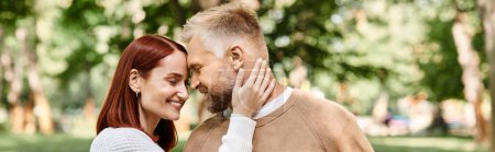 Téléchargez les photos : Un couple aimant en tenue décontractée debout ensemble dans un parc. - en image libre de droit