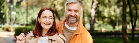 Ein Mann und eine Frau in Freizeitkleidung posieren liebevoll für ein Foto in einem Park.