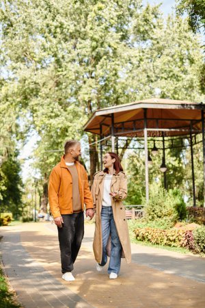 Téléchargez les photos : Un homme et une femme marchent main dans la main sur un sentier pittoresque dans un parc. - en image libre de droit