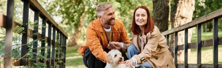 Téléchargez les photos : Couple adulte profitant d'un moment paisible avec leur chien sur un pont. - en image libre de droit