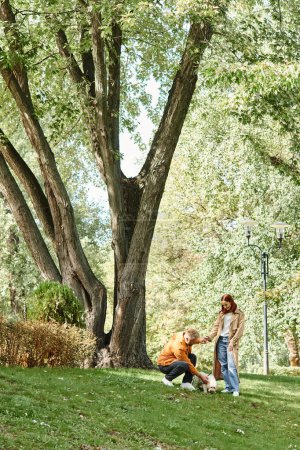 Ein Paar in legerer Kleidung steht zusammen in einem Rasenpark.