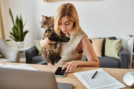 Eine Frau mit kurzen Haaren sitzt an einem Tisch und streichelt zufrieden ihre Katze, die auf ihrem Schoß hockt, und schafft eine heitere Atmosphäre.