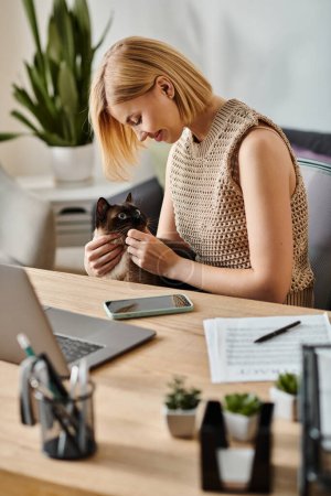 Eine Frau mit kurzen Haaren entspannt am Schreibtisch mit einer Katze auf ihrem Schoß.
