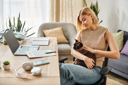 Foto de Una mujer con el pelo corto se sienta tranquilamente en una silla, sosteniendo y vinculando con su amado gato en casa. - Imagen libre de derechos
