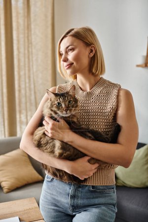 Photo for A woman with short hair tenderly cradling her cat in her arms, sharing a moment of quiet joy at home. - Royalty Free Image