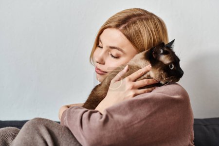 Eine Frau mit kurzen Haaren sitzt auf einem Sofa und hält ihre Katze zärtlich in einem ruhigen und gemütlichen Zuhause.