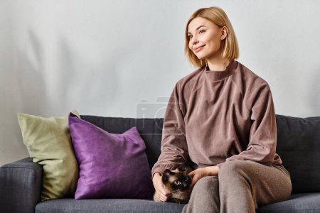 A short-haired woman peacefully sitting on a couch, bonding with her cat.