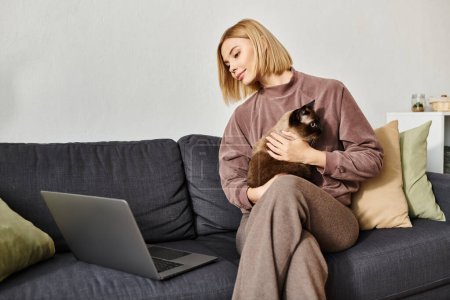 Une femme dans un cadre confortable sur un canapé, tenant son chat près, incarnant un moment serein de compagnie et de détente.